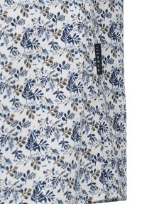 Blumiger Stoff mit marineblauen, blauen und ockerfarbenen Blattmustern auf einem weißen Hintergrund; verfügt über ein Seitenetikett mit dem Text "pugadit".