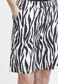 Shorts à imprimé zèbre noir et blanc en tissu léger, dotés d'une taille élastique, de poches latérales et d'une coupe ample.