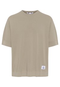 Svetle béžové tričko s krátkým rukávem vyrobené z měkké tkaniny. Má kulatý výstřih a malou bílou štítek s nápisem "M 73" na spodní straně.