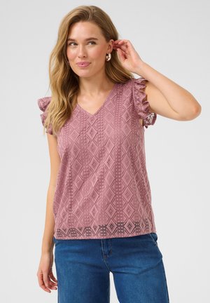 Haut rose à col en V avec une texture à motifs en losange et des manches courtes volantes, associé à un jean bleu.