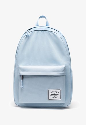 Zaino Herschel azzurro chiaro con tasca frontale con zip e etichetta del marchio nell'angolo in basso a destra su sfondo bianco.