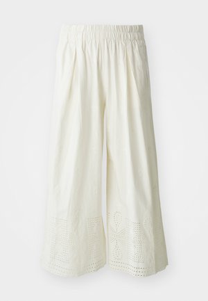 Pantaloni bianchi a gamba larga in tessuto testurizzato, con vita elasticizzata e intricati motivi a taglio sull'orlo.
