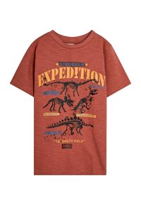 Rode T-shirt met korte mouwen met dinosaurusskeletafbeeldingen, voorzien van de tekst "Dino-expeditie" en ontwerpelementen in zwart en blauw.
