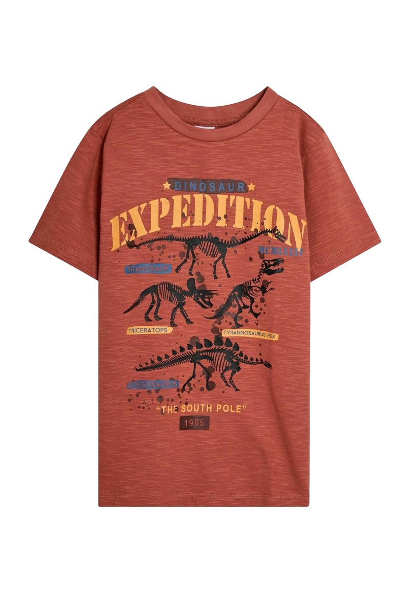 Rode T-shirt met korte mouwen met dinosaurusskeletafbeeldingen, voorzien van de tekst "Dino-expeditie" en ontwerpelementen in zwart en blauw.