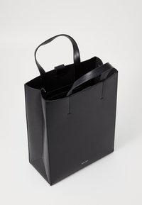 Geantă tote din piele neagră, cu mânere duble, formă rectangulară, închidere cu fermoar superior și detaliu cu logo embosat la bază.