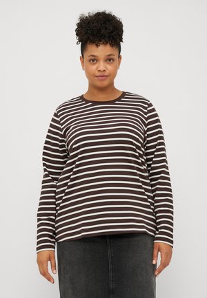 Chemise à rayures brunes et blanches à manches longues, avec un col rond et une coupe décontractée, associée à une jupe en denim foncé. Tissu doux au toucher.