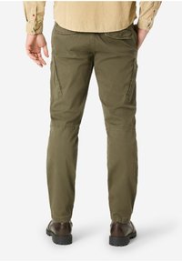 Olive green cargo pants featuring side pockets, a slim fit, and cuffed hems, paired with dark brown shoes. Textured cotton material.