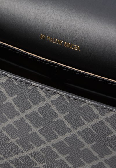 Μαύρη δερμάτινη τσάντα χειρός με υφασμένο γκρι γεωμετρικό σχέδιο. Λογότυπο σε ανάγλυφο χρυσό με την επιγραφή "BY MALENE BIRGER" κατά μήκος της πάνω άκρης.