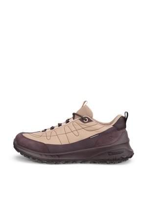 Baskets basses imperméables beige et marron avec une semelle marron foncé dotée d'une semelle antidérapante et de languettes pour tirer sur la languette et le talon.