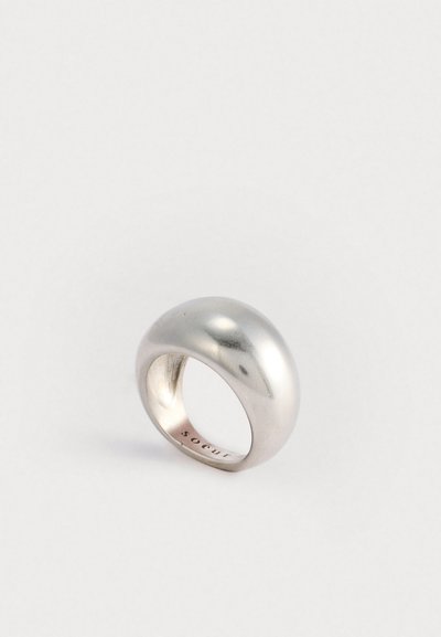 Zilveren metalen ring met een glad, gebogen ontwerp. Kenmerkt zich door een gepolijste oppervlakte en een holle binnenkant, met een merkgravure aan de binnenkant.