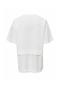 Haut blanc à manches courtes superposé avec une couche supérieure unie et une couche inférieure plus longue et transparente avec un ourlet festonné et une bordure en dentelle.