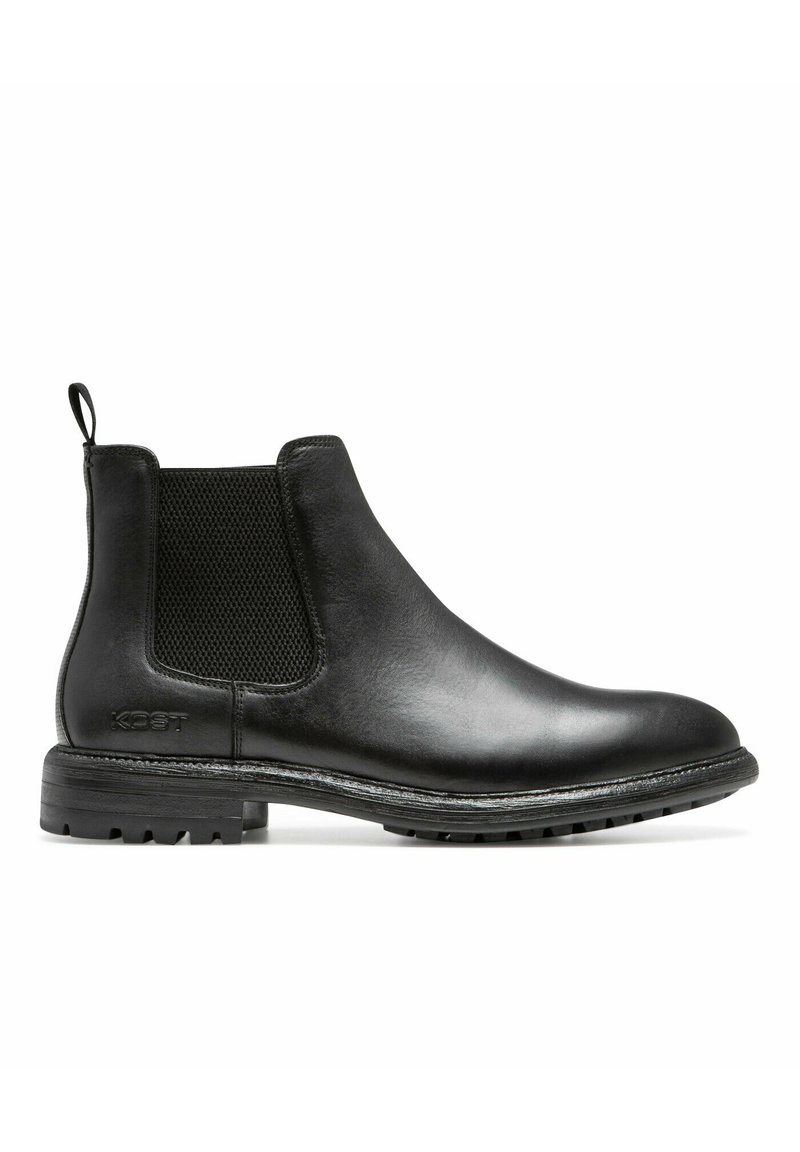 Bottines Chelsea en cuir noir avec des panneaux élastiques sur les côtés et une languette de tirage. Semelle en caoutchouc noir texturé et coutures visibles le long du bord.