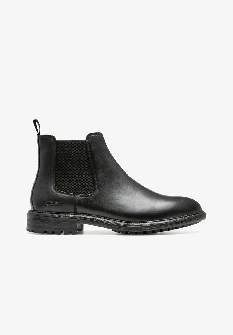 Bottines Chelsea en cuir noir avec des panneaux élastiques sur les côtés et une languette de tirage. Semelle en caoutchouc noir texturé et coutures visibles le long du bord.