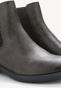 Botas de tobillo de cuero gris con paneles laterales elásticos, puntas redondeadas y una textura suave. Suela de goma negra baja para mayor tracción.