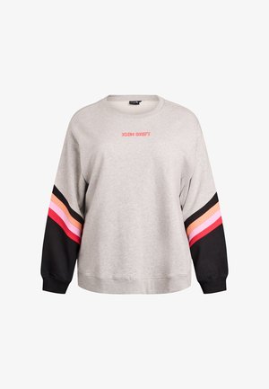 Jasnoszara bluza z czarnymi rękawami ozdobiona różowymi, czerwonymi i pomarańczowymi paskami oraz napisem „ICON SHIFT” w kolorze różowym umieszczonym na środku klatki piersiowej.