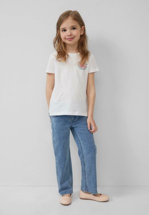 Weißes Baumwoll-T-Shirt mit einem Wassermelonen-Motiv, kombiniert mit hellblauen Jeans und hellbeigen flachen Schuhen. Einfaches Design, lässiger Schnitt.