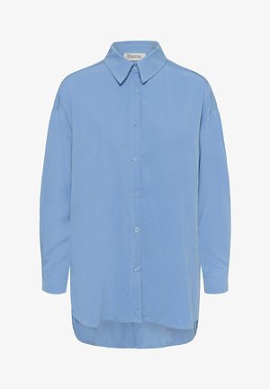 Cămașă albastru deschis cu mâneci lungi, nasturi și guler ascuțit, cu tiv ușor curbat, etichetată "Dulapul meu esențial".
