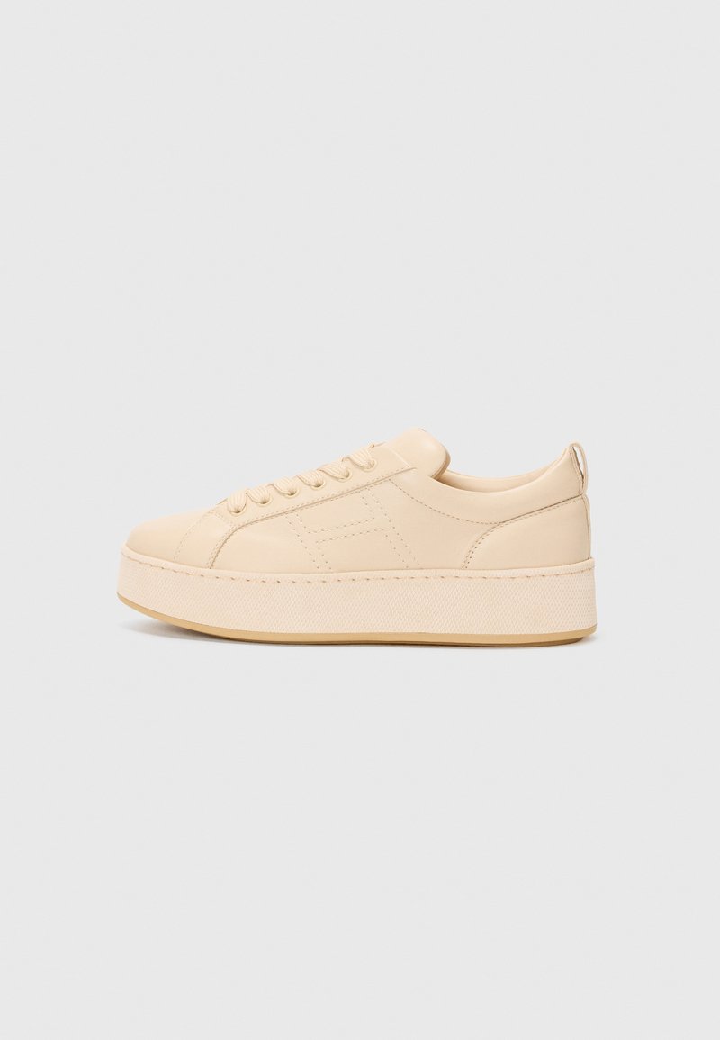 Beige Low-Top-Sneaker mit einem strukturierten Lederoberteil, runder Zehenpartie, flacher Plattformsohle und detaillierter Naht entlang der Kanten.