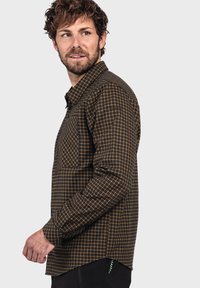 Langärmliges kariertes Hemd in Braun mit gelbem Karomuster, ausgestattet mit einer Brusttasche und knöpfbaren Manschetten, aus einem weichen Stoff gefertigt.