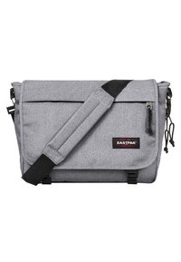 Borsa a tracolla grigia realizzata in tessuto resistente, con chiusura a patta, tracolla regolabile, etichetta con logo e tasca laterale con zip.