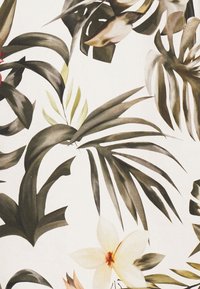 Bloemmotief op stof met grote donkergroene en lichtgroene bladeren, met crèmekleurige en lichtgele bloemen die door elkaar verspreid zijn.