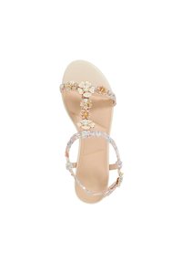 Beaded sandal featuring a nude base, floral embellishments, pearl accents, and a clear strap with multi-colored flecks. Flat sole design.