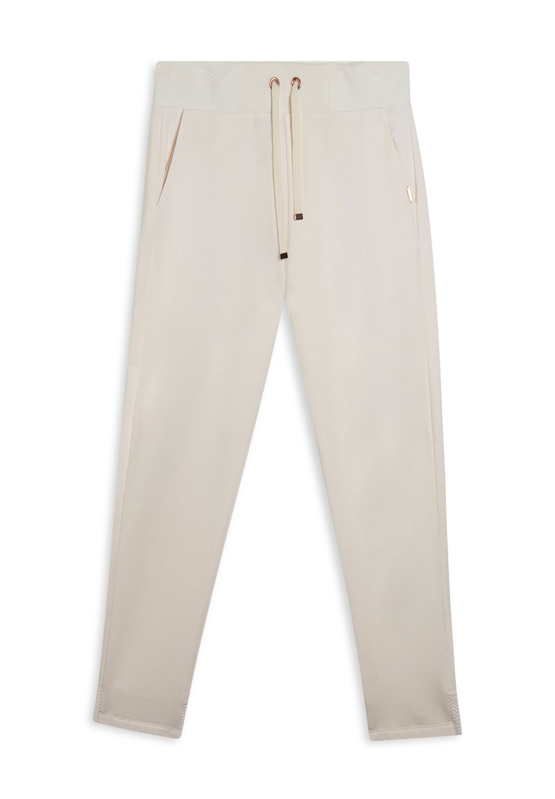 Pantalons de survêtement beige en tissu doux, avec une taille texturée, un cordon de serrage réglable et des poches latérales. Coupe slim avec des accents côtelés.