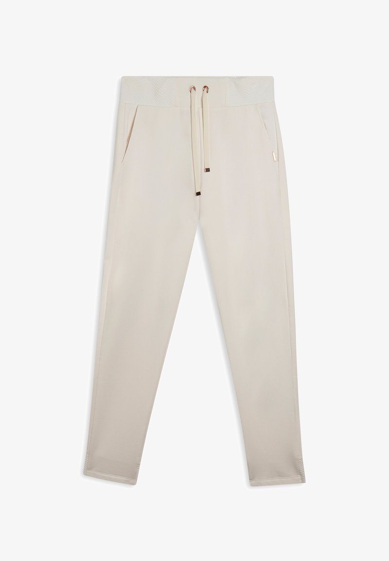 Pantalons de survêtement beige en tissu doux, avec une taille texturée, un cordon de serrage réglable et des poches latérales. Coupe slim avec des accents côtelés.