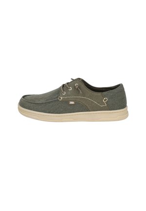Zapatilla casual verde para hombre de lona con suela beige, diseño con cordones y detalles cosidos en el lateral.