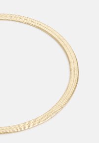 Collana in metallo color oro con design flessibile e piatto. Presenta una texture liscia e una forma rotonda affusolata con anelli intrecciati.