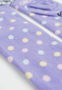 Tessuto viola con pois pastello gialli, blu e rosa in una vista ravvicinata, che mostra dettagli di texture e motivo.