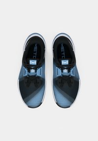 Μαύρα και μπλε αθλητικά παπούτσια με υφασμάτινη επάνω επιφάνεια με υφή, διαθέτοντας διαγώνια μπλε σχέδια, μαύρες κορδόνες και λευκές σόλες.