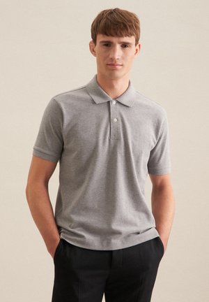Graues Poloshirt mit Kragen, kurzen Ärmeln, einer Drei-Knopf-Leiste und einer weichen Textur, kombiniert mit dunklen Hosen.