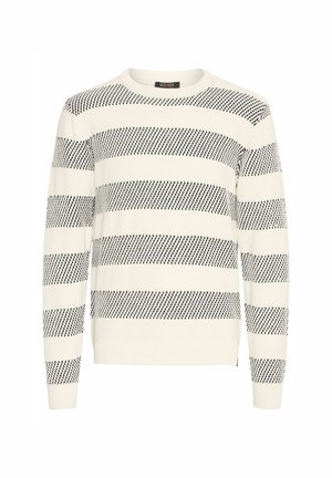 Strikket trøje i creme med sort stribet mønster, rund halsudskæring, struktureret stof samt ribbet manchetter og kant. Mærket er synligt ved halsudskæringen.