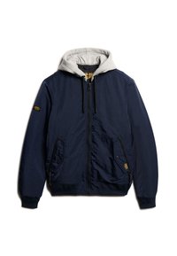 Marineblauwe bomberjack met een grijze hoodievoering, voorrits, zijzakken en een gestructureerde afwerking. Voorzien van een logo op de borst.