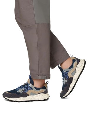 Marineblaues und braunes Sneaker-Modell mit Mesh-, Wildleder- und strukturierten Materialien, ausgestattet mit blauen Schnürsenkeln und einer gesprenkelten weißen Sohle. Lässiges Design mit einem mehrschichtigen Look.