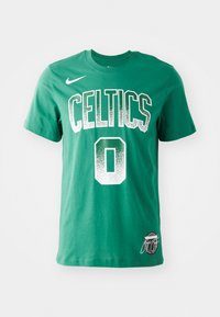 Green cotton t-shirt featuring "CELTICS" text and number "0" in white with a gradient effect; includes Nike logo and signature detail on hem.