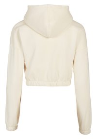 Kuttet hettegenser i lys beige, med snøring i hetten, lange ermer og elastisk midjebånd nederst for en tettsittende look.