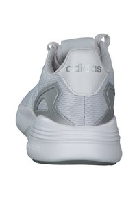 White athletic shoe with a textured mesh upper, gray accents, and a padded heel counter featuring the Adidas logo. Durable rubber sole.