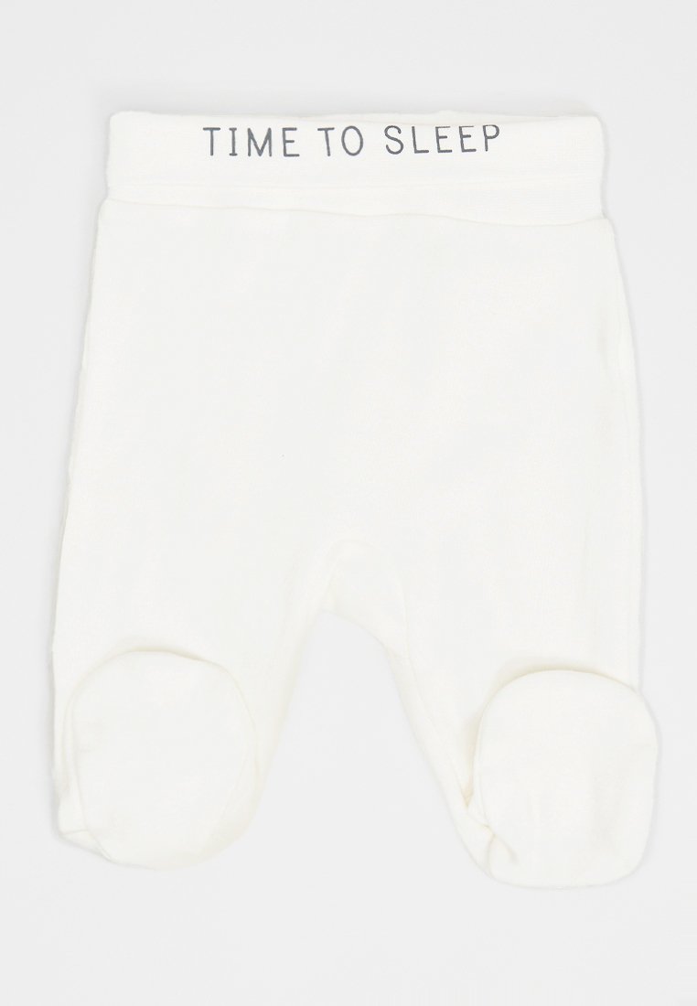 Pantalones de dormir para bebé blancos con pies y el texto "ES HORA DE DORMIR" en la cinturilla, presentados sobre un fondo sencillo.