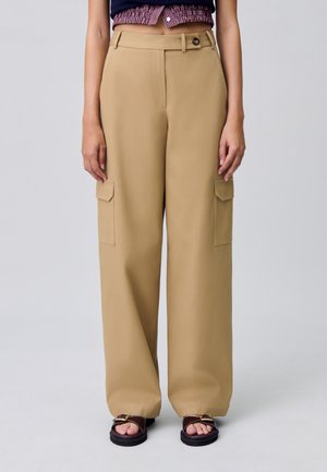 Pantalones cargo de pierna ancha beige con dos bolsillos laterales, cierre de botón y trabillas para cinturón, hechos de una tela suave.