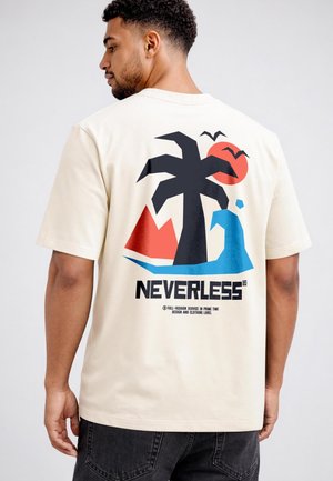 Man in a beige T-shirt with a graphic of a palm tree, sun, sea, birds, and the word "NEVERLESS" on the back, standing sideways.