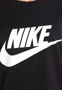 Schwarzes Baumwoll-T-Shirt mit einem großen weißen Nike-Logo und Swoosh-Design; Rundhalsausschnitt und kurze Ärmel. Glatte Textur.