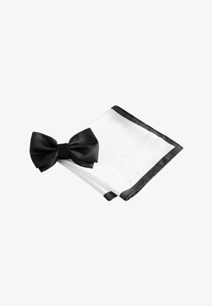 Fekete szatén csokornyakkendő egy összehajtott fehér zsebkendőn fekete szegéllyel, mindkettő fehér háttéren.