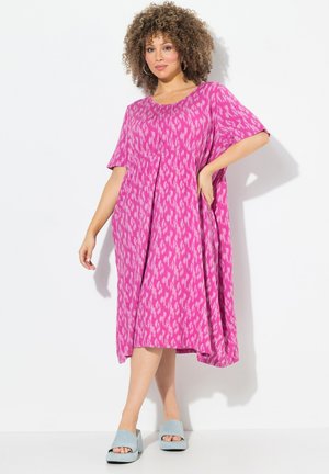 Abito rosa con motivi, maniche corte, pieghe e vestibilità ampia. Abbinato a sandali platform azzurri chiari. Tessuto dalla texture morbida.