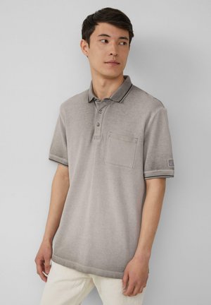 Grijze polo shirt met een kraag, drie knopen en een borstzakje. Heeft contrasterende donkere biezen op de kraag en de mouwen.