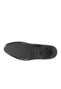 Suola di scarpa in pelle nera con grip texturizzato, forma allungata e bordi lisci; presenta un logo impresso e dettagli minimi.