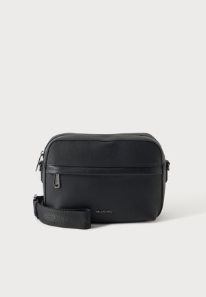 Sac bandoulière noir Valentino avec finition texturée, poche avant zippée et sangle réglable avec nom de marque embossé.