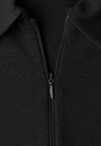 Schwarzer Kapuzenpullover mit Reißverschluss, mit glatter Textur, einem zentralen Reißverschluss und Kragen, gefertigt aus elastischem Stoff.