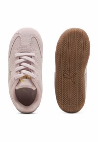 Zapatillas de ante rosa claro con diseño de cordones, acentos beige y una suela de goma texturada. Presenta un detalle del logo en dorado.
